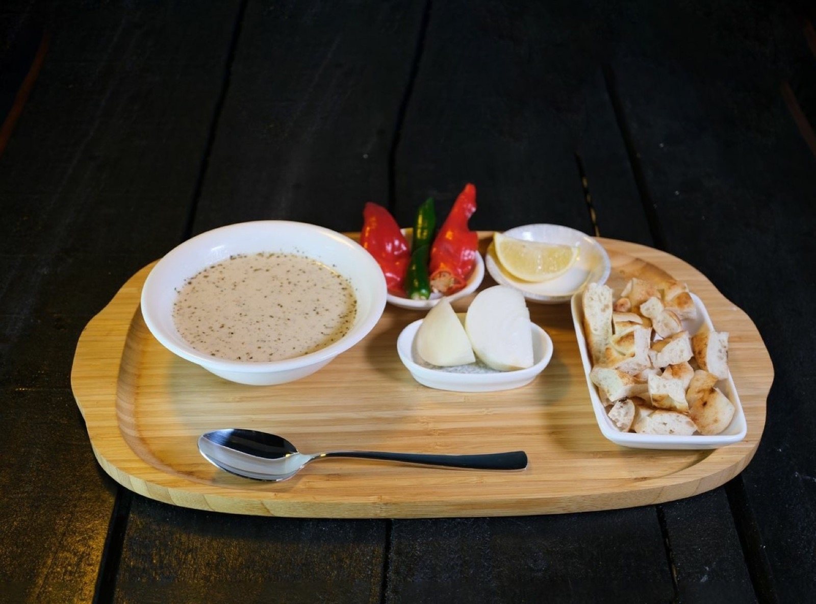 Ahşap tepside yayla çorbası, közlenmiş biber, limon ve ekmek