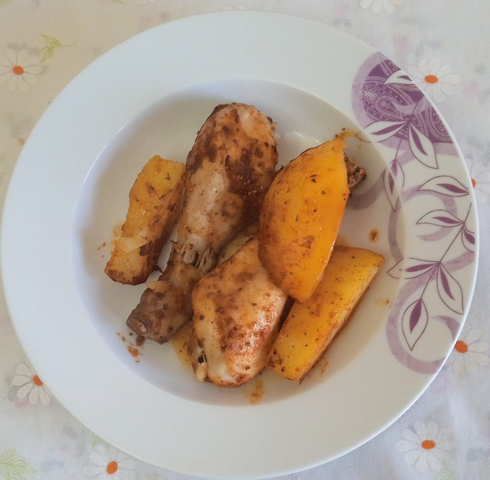 Fırında baharatlı tavuk bagetler ve patates dilimleri, çiçek desenli tabakta