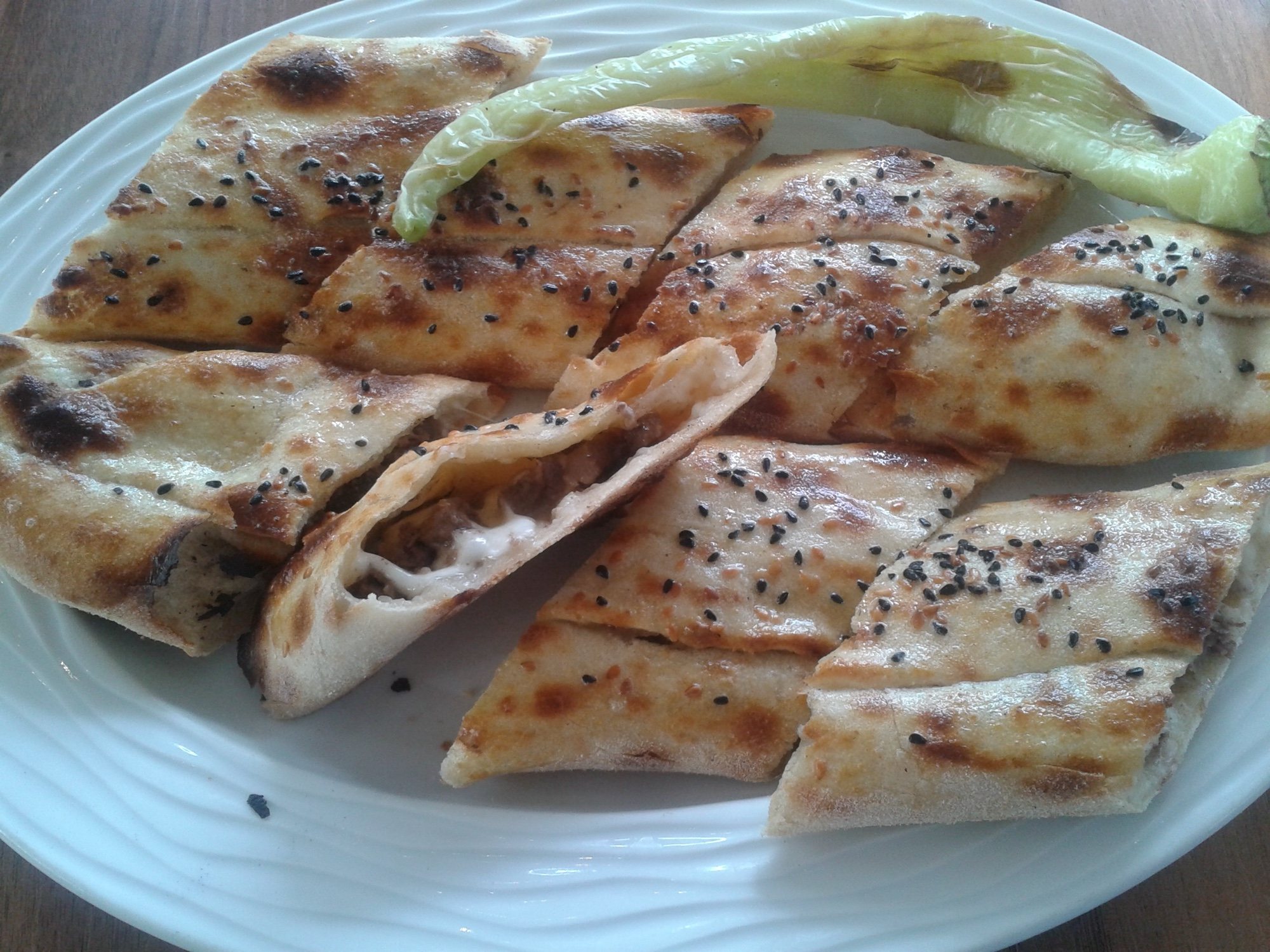 İçi kavurma ve eriyen kaşarla dolu, çörek otlu kapalı pide dilimleri
