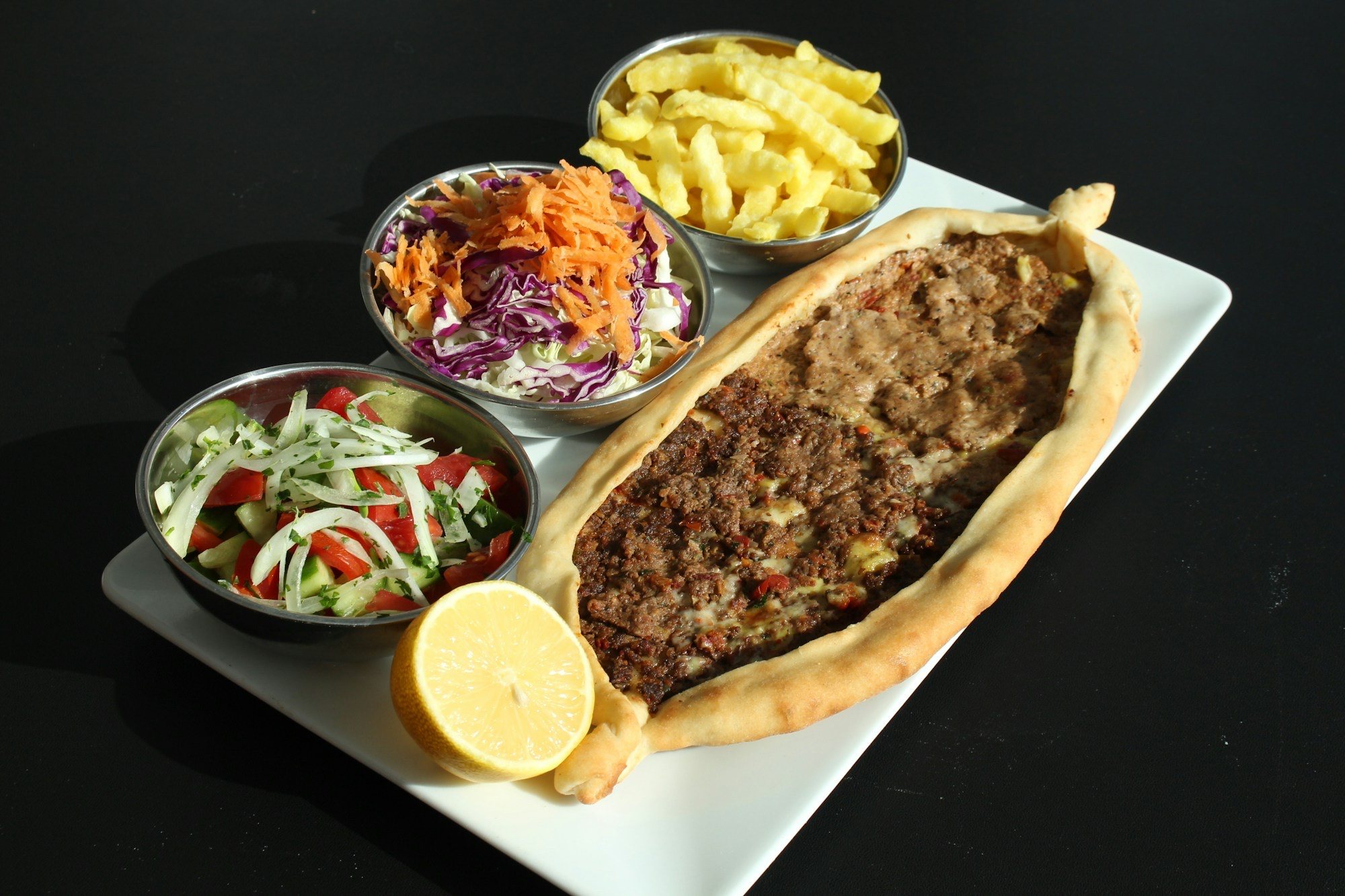 Kıymalı Kaşarlı Pide için temsilî görsel: Kıymalı pide; yanında salata, havuç-lahana, patates kızartması ve limonla