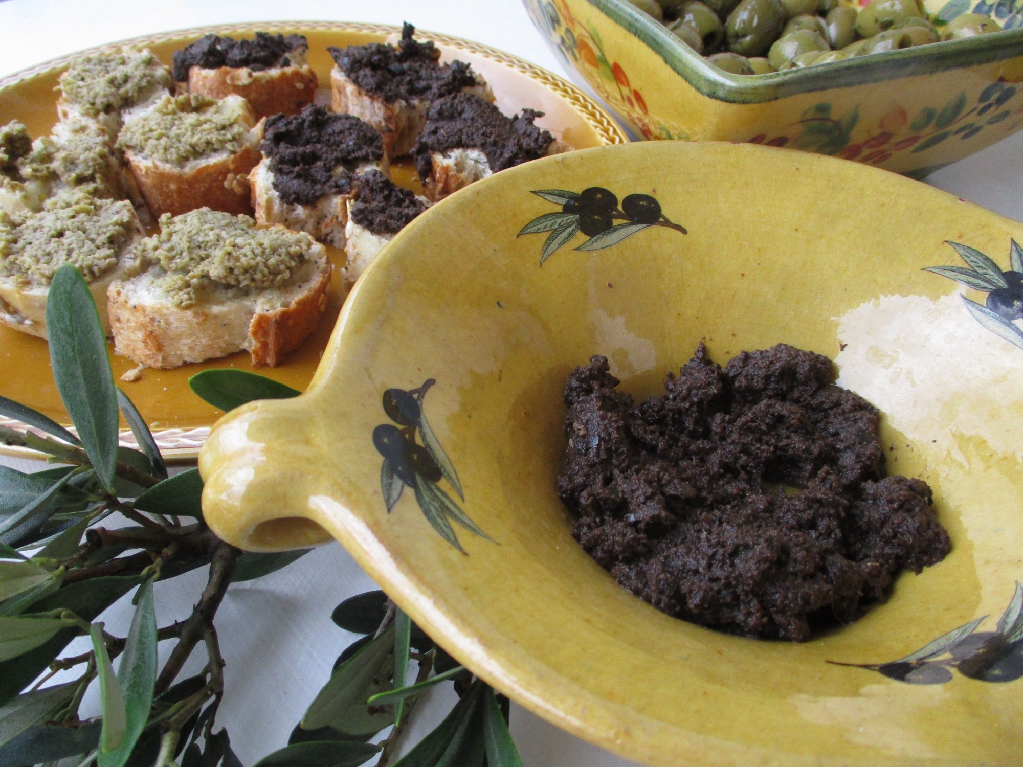 Kâsede siyah zeytin ezmesi ve zeytin ezmesi sürülmüş kızarmış ekmek dilimleri